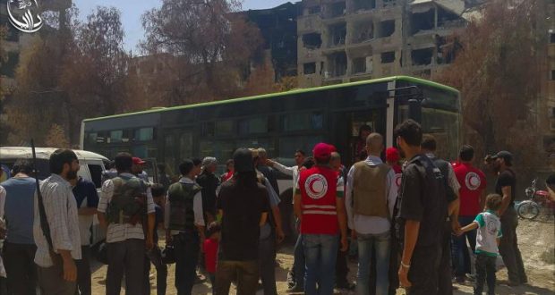 جانب من المدنيين الذين سيتم إجلاؤهم بالقرب من حافلة تتولى نقلهم (ناشطون